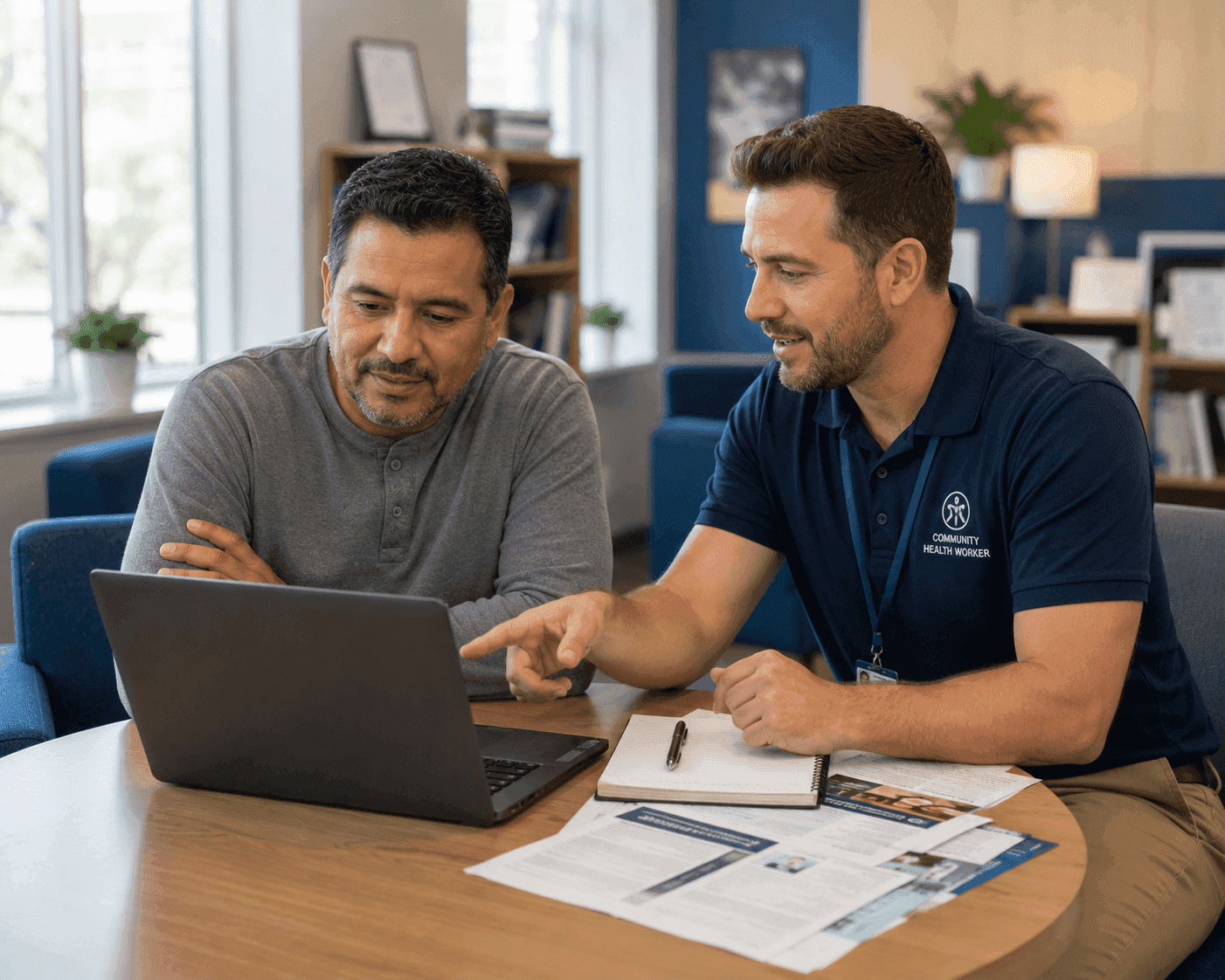 Community health worker assisting an individual with housing resources on a laptop